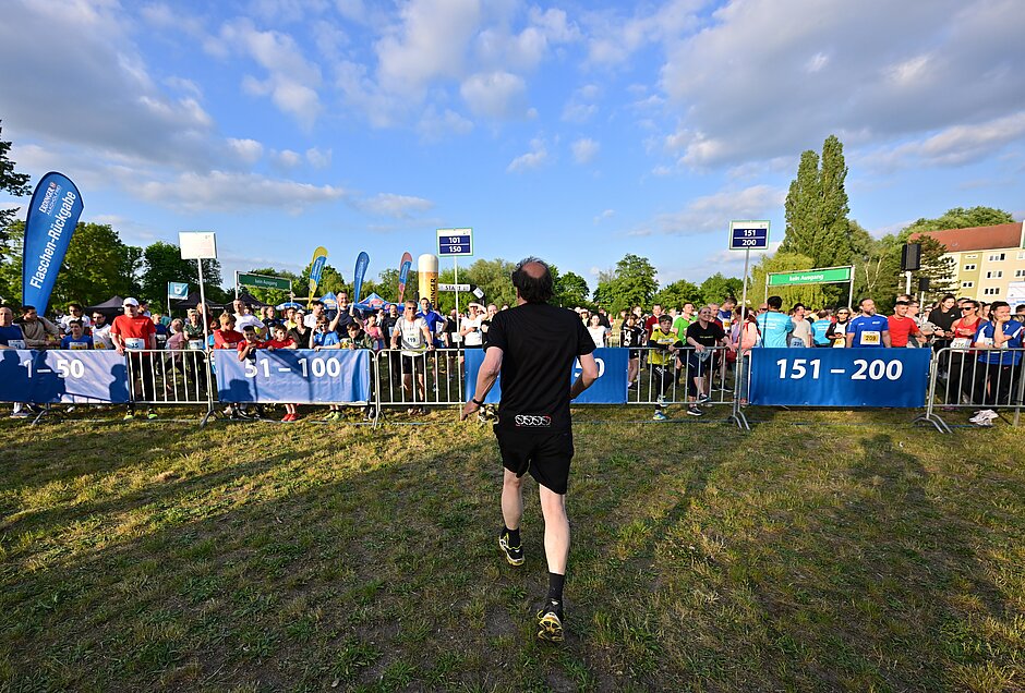 Team Staffel Brandenburg Anmeldung: Läufer steuert in der Wechselzone auf die Teams zu @ SCC EVENTS / Petko Beier