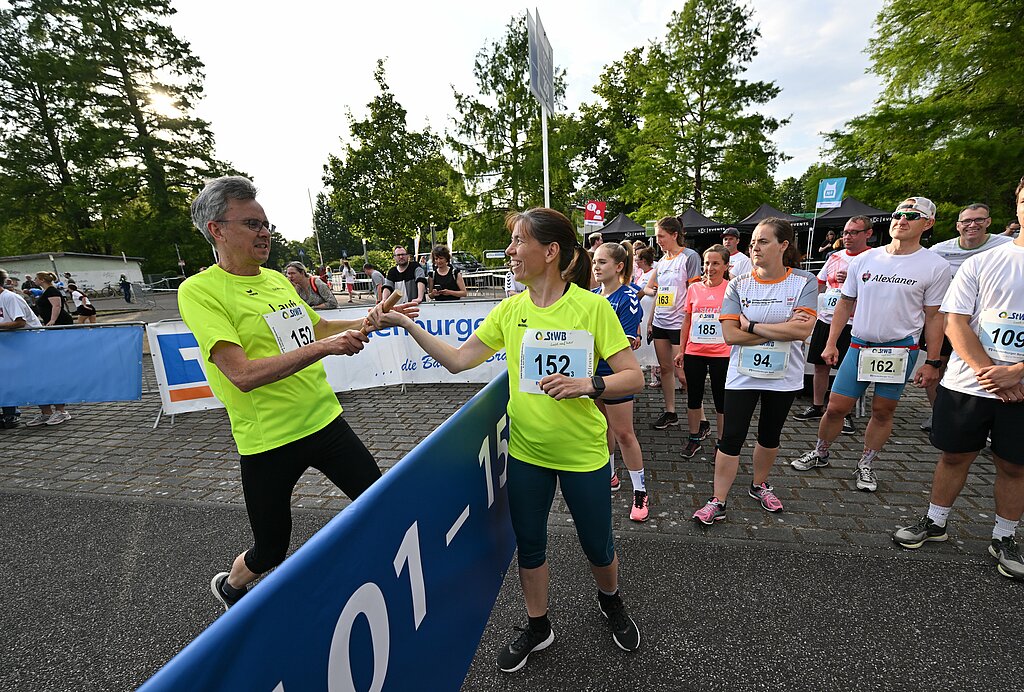 Team Staffel Brandenburg Fotos (2023): Teammitglieder in gelben Shirts übergeben den Staffelstab @ SCC EVENTS / Petko Beier 