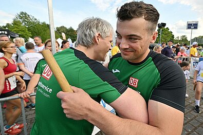 Team Staffel Brandenburg Fotos (2022): Zwei männliche Läufer umarmen sich bei der Übergabe des Staffelstabs